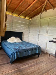 a bed in a room with a wooden floor at Cómoda Finca de Descanso en Urabá in Estación El Salto