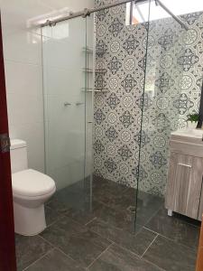a bathroom with a toilet and a glass shower at Cómoda Finca de Descanso en Urabá in Estación El Salto