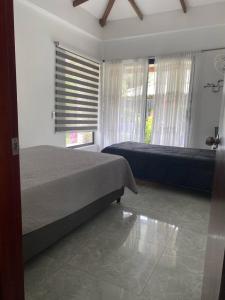 a bedroom with two beds and a window at Cómoda Finca de Descanso en Urabá in Estación El Salto +5 photos