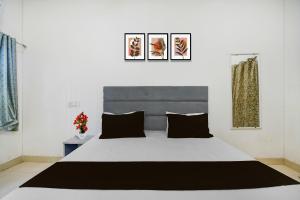 a bedroom with a large white bed with black pillows at Hotel O BHU Formerly The Regal Inn in Kakarmatha +7 photos