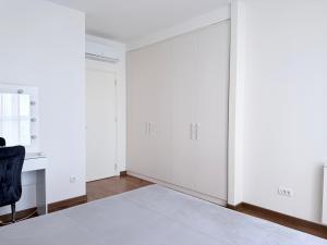 贝尔格莱德BW Arcadia RIVÉ Apartment的一间空房间,配有床和椅子