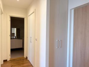 贝尔格莱德BW Arcadia RIVÉ Apartment的一条有白色墙壁的走廊和一间带门的房间 更多6张照片
