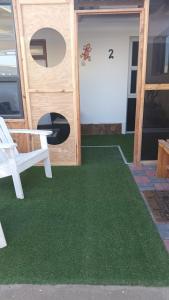 リューデリッツにあるScholtz Self-catering accommodationの緑の床と椅子のあるドアのある家