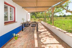 patio con tavolo e sedie sotto tenda di Casa do Canal - Zambujeira do Mar a São Teotónio