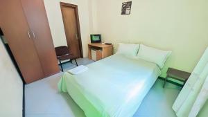 a bedroom with a large white bed and a desk at Wib Guesthouse in Addis Ababa
