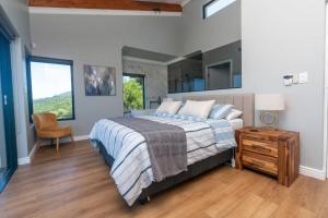 a bedroom with a bed and a chair and a window at FrizNite 1 in Brenton-on-Sea