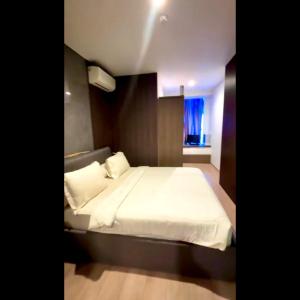 a bedroom with a bed with white sheets and a window at 31 Sudirman Suites in Makassar +3 photos