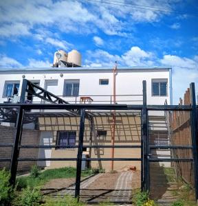 a white house with a building in the background at El Parque in San Luis