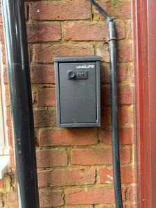 a utility box on the side of a brick wall at COSY Rooms in Grove Park