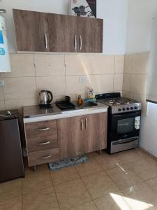 a kitchen with wooden cabinets and a stove top oven at El Parque in San Luis