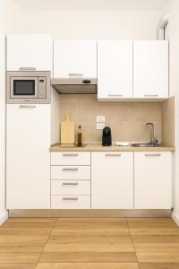 a kitchen with white cabinets and a microwave at Residence Antares in Riccione