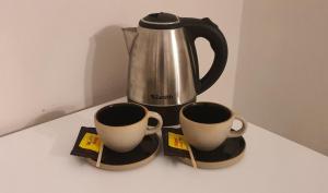 two coffee mugs and a tea kettle on a counter at Hotel Cuba in Buenos Aires