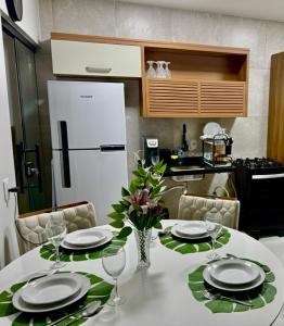 a kitchen with a table with plates and wine glasses at Le Chardon Residence in Ananindeua