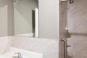 a bathroom with a sink and a shower with a mirror at Starlite Motel in San Bernardino
