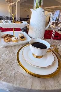 a cup of coffee on a plate on a table at La Gabbanee Hotel Boutique in Fernando de la Mora