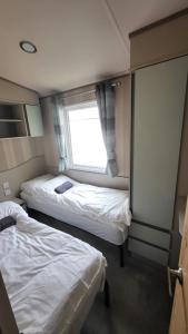 two beds in a small room with a window at East Lothian Escape in Port Seton