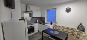 ジーゲンにあるMonteur- und Ferienwohnung Siegen Millerのテーブルと冷蔵庫のある小さなキッチン