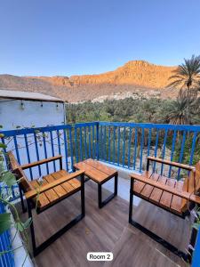 Un balcón con dos bancos y vista al desierto. en Hawer Inn - wadi bani Khalid, en Biḑ‘ah
