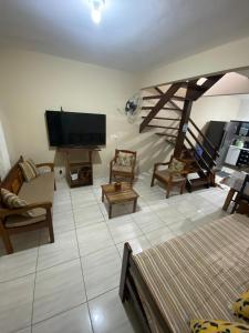 a living room with a flat screen tv and furniture at Casa Azul Paraty in Paraty