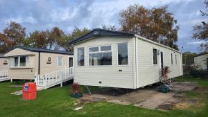 a white tiny house parked in a yard at East Lothian Escape in Port Seton