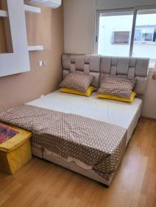 a bedroom with a large bed with pillows on it at Studio Charmant & Cosy à Agdal in Gare de Rabat-Aguedal
