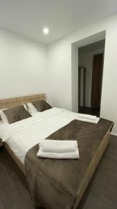 a bedroom with two beds with white sheets and a mirror at My Apartment in Kvareli