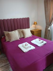 a purple bed with two towels on top of it at My House in El Calafate. in El Calafate