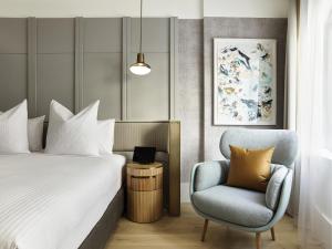 a hotel room with a bed and a chair at The Porter House Hotel Sydney - MGallery in Sydney