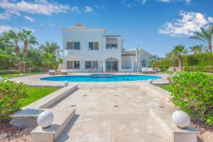 eine große Villa mit Swimmingpool und Palmen in der Unterkunft Beautiful 4 BDR Villa With Private Pool in Hurghada