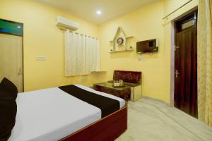 a bedroom with a bed and a tv in it at Hotel O Krishna Palace in Jaipur
