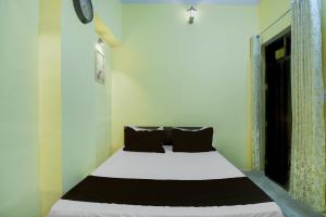 a bedroom with a white bed with black pillows at Hotel O Krishna Palace in Jaipur +22 photos