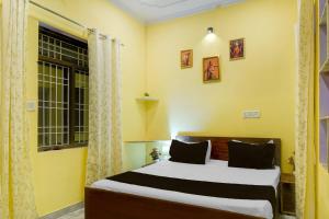 a bedroom with a bed and a window at Hotel O Krishna Palace in Jaipur