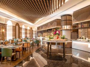 une salle à manger avec des tables et des chaises dans un restaurant dans l'établissement Pullman Haikou, à Haikou