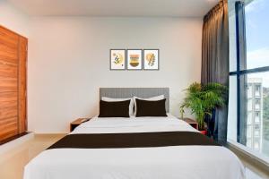 een slaapkamer met een groot bed en een raam bij Hotel O Lotus Inn in Chinchwad