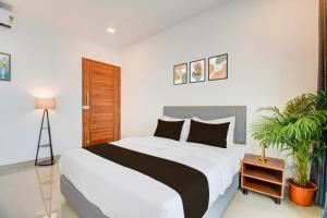 een slaapkamer met een groot bed en een plant bij Hotel O Lotus Inn in Chinchwad