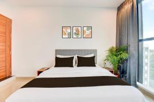 een slaapkamer met een bed en een groot raam bij Hotel O Lotus Inn in Chinchwad +23 foto's