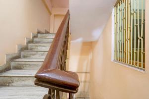 una escalera con barandilla marrón en un edificio en SPOT ON Welcome Guest House, en Mughal Sarāi