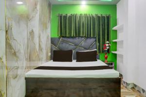 Un dormitorio con una cama grande con una pared verde. en SPOT ON Welcome Guest House, en Mughal Sarāi