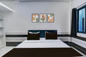 a bed in a room with three paintings on the wall at Hotel O Royal Palace Hotel in Sheodāspura +23 photos
