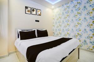 a bedroom with a large bed with blue and yellow wallpaper at HOTEL O HAVELI INN in Rāipur
