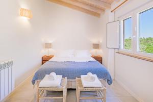 una camera da letto bianca con un letto e due sedie di Casa do Canal - Zambujeira do Mar a São Teotónio