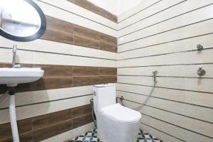 a bathroom with a toilet and a sink at Hotel O Celebration in Indraprast
