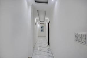 a hallway with white walls and marble floors at Hotel O Celebration in Indraprast