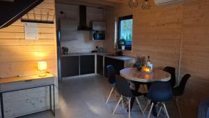 een keuken met een tafel en stoelen in een kamer bij Domki Morskie Jastrzębia Góra - Domki z basenem in Jastrzębia Góra