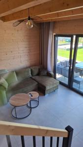 een woonkamer met een bank en een tafel bij Domki Morskie Jastrzębia Góra - Domki z basenem in Jastrzębia Góra