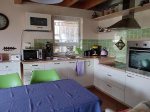 a kitchen with a table and green chairs in it at Casa Luna in Herdwangen-Schönach