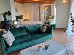 a living room with a green couch and a bed at Casa Luna in Herdwangen-Schönach