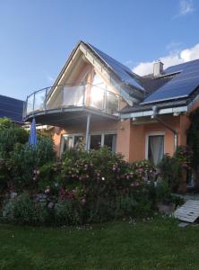 a house with a glass roof and some flowers at Casa Luna in Herdwangen-Schönach