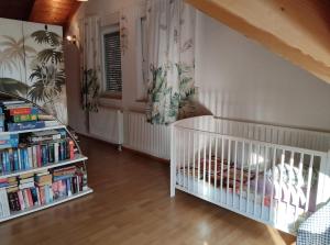 a baby room with a crib and books at Casa Luna in Herdwangen-Schönach