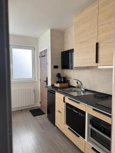 a kitchen with wooden cabinets and a sink and a window at WelKom Studios in Zaventem +6 photos